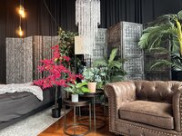 the corner in elevation boudoir's studio that include a bed with multiple sheet color options, a chich crystal chandelier and a leather club chair perfect for posing on
