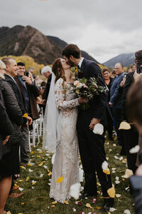 bride and groom kiss at altar