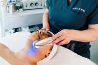Aesthetician providing LED therapy during her brand photography session