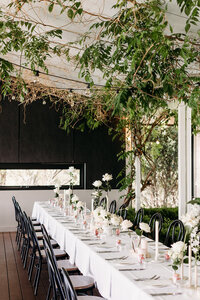 Table decorations and white roses in bud vases at Brindabella Hills Winery