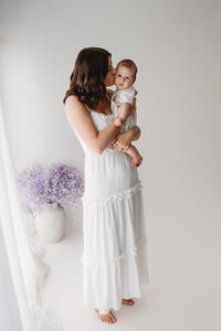 Charleston Mini Sessions - Mother embraces her baby during Mother's Day Mini Session at Holy City Babies in Charleston, SC.