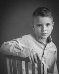 Young boy studio portrait iwith a serious face n black and white,