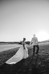 Groom leading bride up the hill outside the Marion for sunset portraits on their wedding day. Photo by Acacia & Grace Photography
