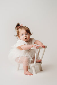 Charleston Cake Smash Photographer- Baby looks into the camera during Milestone Portraits at Holy City Babies Portrait Studio in Charleston, SC.