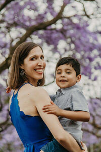 A mom and son photographed in front of an avenue of Jacarandas in Johannesburg
