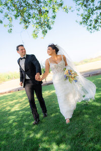 bride and groom running under willow tree at rainbow oaks ranch in sanger california