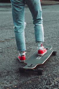 Color detail of red sneakers and a skateboard during a creative brand photography session
