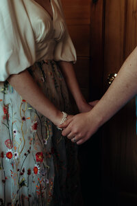 Newly married couple standing outside Airbnb cabin in North Georgia mountains for cinematic photos. Photos by Crimson Conure Photography based in Kennesaw, Georgia and Denver, Colorado