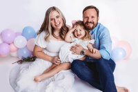 Parents embrace their toddler during Milestone Portraits and Cake Smash Photos in Charleston, SC.