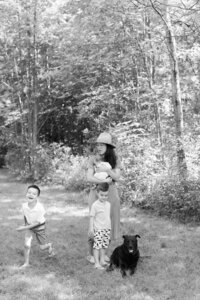 Kim-Trang holds her newborn son while her children run around them