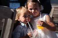 Brother and sister enjoying orange juice at a wedding