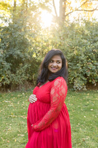 pregnant woman smiling with hand on belly- Waterford Michigan Maternity Newborn Photography