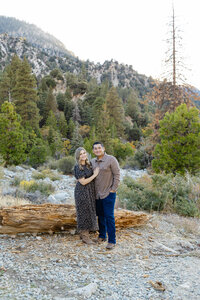 Couple embracing outdoors in a scenic mountain landscape with soft natural light, romantic lifestyle portrait by Kaitlyn Dawn Photography, professional family and couple’s photographer.