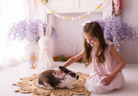 Little girl pets a live bunny during Easter Mini Session at Holy City Babies Portrait Studio in Charleston, SC.