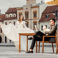 A wide shot of a rustic barn-style wedding venue in Transylvania, with elegant outdoor table settings and natural textures, captured by a UK wedding photographer.