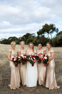Bridesmaids standing together outdoors with bouquets