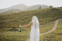 Utah bride celebrates marriage with a bottle of champagne in the mountains around Salt Lake City.