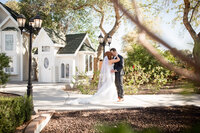 Bride and groom kissing while walking through the courtyard at their wedding venue