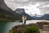 Newlyweds hug and enjoy the views of peaks and glaciers after a beautiful elopement ceremony in Glacier National Park.