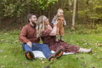 man, woman and baby posing on ground in Oakland County family photographer Savvy Shoots Photography