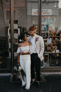 bride and groom stand outside of cool shop in fitzroy