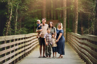Allie Cline with her family walking across a wooden bridge in North Carolina
