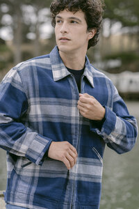 Blue and grey plaid flannel zip jacket over a black tee, apparel campaign frame