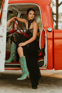 Senior portrait at Triple T Farms in Fruitdale, Alabama — sitting in the driver’s seat of a classic
red truck, looking off into the distance.