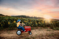 Charleston Baby Milestone Photographer - Baby rides on a pedal tractor during his Milestone Portrait Session at Holy City Babies Portrait Studio in Charleston, SC.
