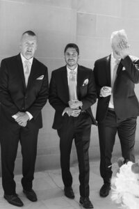 san francisco city hall wedding emotional groomsmen in hallway