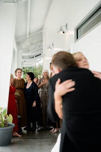 A poignant in-between moment of a bride being embraced by her father, focusing on preserving atmosphere and emotion over posed shots.