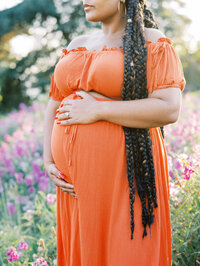 Closeup of expecting mom cradling her body, her hair falling on the sides.