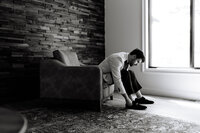 Smoky Mountain groom adjusting shoes while getting ready