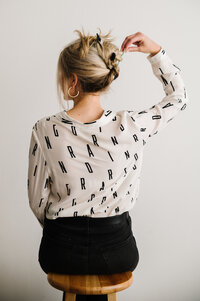 The back of Sarah Klongerbo pulling her hair up with pens