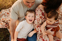 little boy smiling with family members