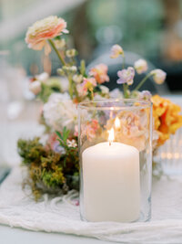 gold rimmed candle votive with white rose flower centerpiece for a wedding reception.