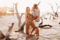 Folly Beach Maternity Photographer -- Pregnant woman poses for Maternity Photos at the Lighthouse Inlet Heritage Preserve on Folly Beach with iconic views of the Morris Island Lighthouse in the distance.