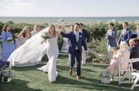Bride and Groom celebrate as they walk back down the aisle after wedding ceremony.