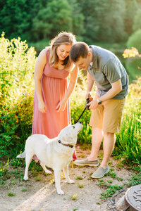 Couple plays with dog by lakeside in Springfield, VA