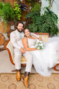 A married couple poses on a vintage couch at The Atrium in Solon Springs