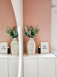 Hal-scandinavisch-warm roze-poster-plant-geurstokjes-witte schoenenkast-grote ronde spiegel
