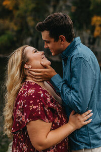 minnesota fall engagement session closeup of man holding womans face lovingly