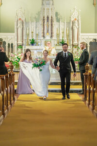 Bride and groom exiting the church in Los Angeles after the ceremony, captured in a joyful documentary style moment.