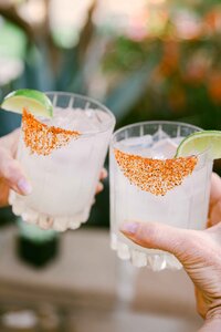 Two chile-rimmed margaritas raised in a toast