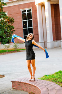 MTSU Senior dancing outside the campus library with her graduation stole