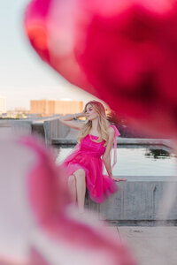 Barbie girl in a tulle hot pink dress in downtown Houston with balloons framing her