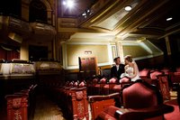 A teacher couple sit in an old theater on their wedding day.