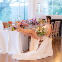 editorial bride sitting at tablescape drinking champagne at hollins house in santa cruz