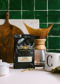 Lifestyle-inspired product photography of packaged coffee styled in a home kitchen setting with natural light and everyday props