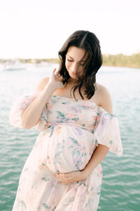 Pregnant woman holding belly at sunset on Miami Beach, maternity photographer South Florida